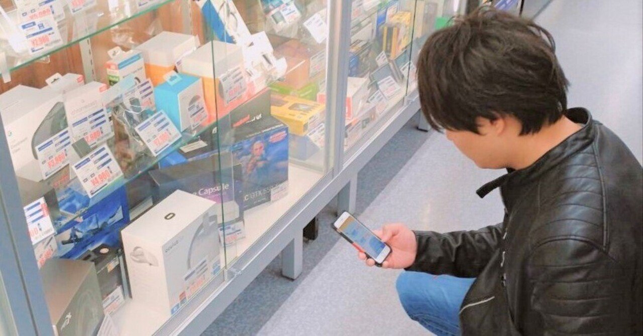 店舗で商品をスマートフォンで調べるマツオ